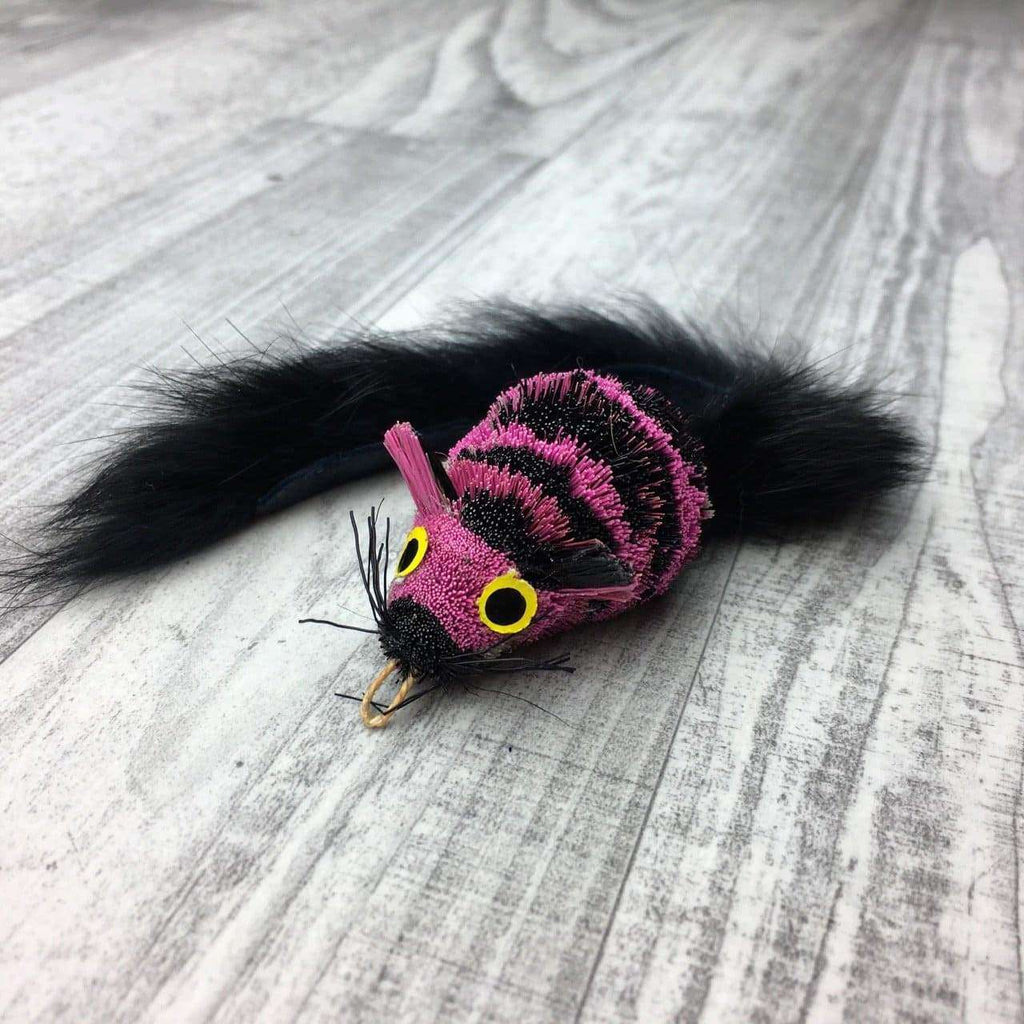 This is a Pretty Fly Mouse Teaser Wand Cat Toy Replacement Lure by Catboutique. The lure is made of real deer fur. The lure has a cotter clip ring where the mouth should be. It has a long bushy tail too. The lure is colored with a dye that isn't harmful to cats. This mouse has two huge eye that stand apart from the body. The mouse is hot pink and black striped with a grey underbelly. This lure is meant to engage at the cat's hunting instincts like prowling, pawing, and pouncing. 