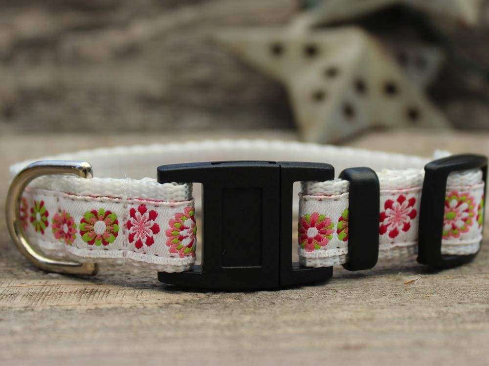 This is the Winter Garden Breakaway Buckle Cat Collar by Surf Cat. It features floral patterns set on a winter white fabric. The has breakaway buckles that pop open under eight pounds of pressure. This helps reduce choking hazards. The collar is made with soft and comfortable nylon overlaid with durable polyester ribbon. uintuple stitching at stress points provides extra strength too. So your cat gets a strong, comfortable collar.  Edit alt text