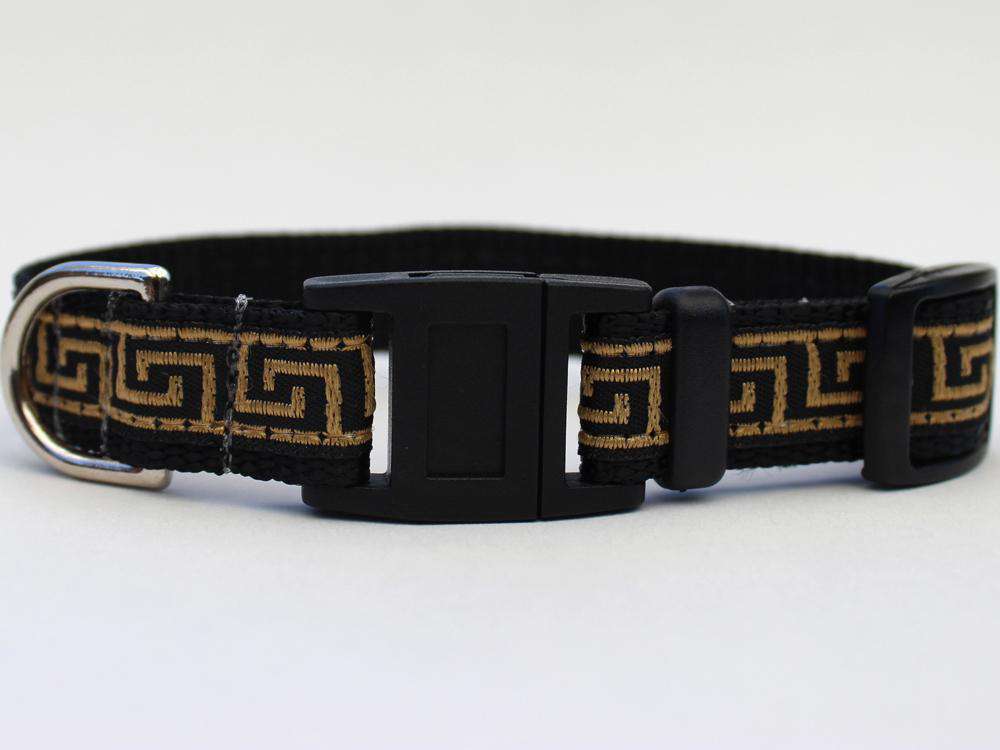 This is the Caesar Break Away Cat Collar by Diva Dog and Surf Cat. The collar has a Greek geometric design, with lines creating a maze look across the collar. The lines are of golden brown hue. The collar was manufactured in the USA. It has breakaway buckles that pop open under a minimal eight pounds of pull, which helps prevent choking. The collar is made of of soft and comfortable nylon overlaid with durable polyester ribbon. The material is quintuple stitched at stress points for added strength. 