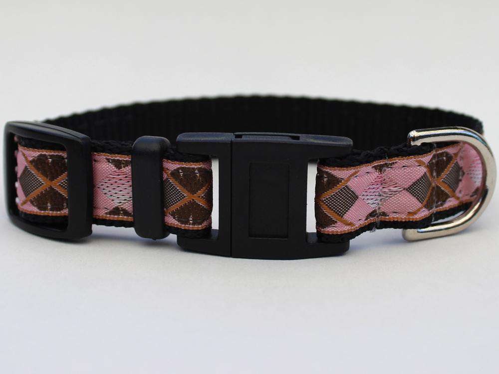 This is the Argyle Design Breakaway Buckle Cat Collar by Surf Cat. It features a pink, grey, copper, and black argyle design that resembles some golfer's clothing. The collar features  breakaway buckles that pop apart under eight pounds of pressure, which reduces the chances of choking. It's made of cozy and pliable nylon overlaid with lasting polyester ribbon. This creates comfort and a strong collar for your cat. Plus, the quintuple stitching at stress points provides crazy additional durability.