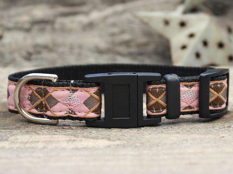 This is the Argyle Design Breakaway Buckle Cat Collar by Surf Cat. It features a pink, grey, copper, and black argyle design that resembles some golfer's clothing. The collar features breakaway buckles that pop apart under eight pounds of pressure, which reduces the chances of choking. It's made of cozy and pliable nylon overlaid with lasting polyester ribbon. This creates comfort and a strong collar for your cat. Plus, the quintuple stitching at stress points provides crazy additional durability.