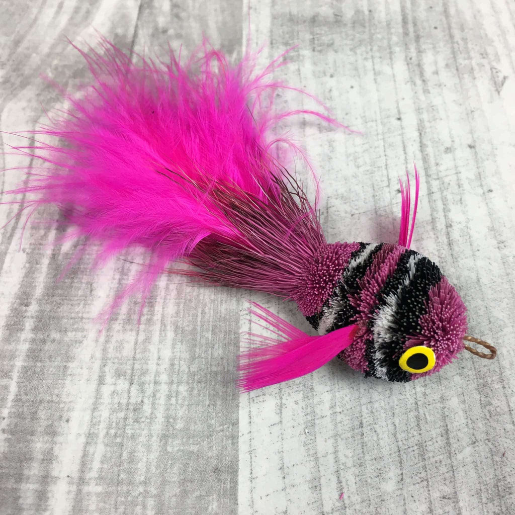 This is a Pretty Fly Clownfish Teaser Wand Cat Toy Replacement Lure by Catboutique. It is hot pink.  The fish has black and white stripes. There is a feather tail. The lure is made of deer hair and is dyed a dye that isn't harmful to cats. This lure is meant to engage at the cat's hunting instincts like prowling, pawing, and pouncing.