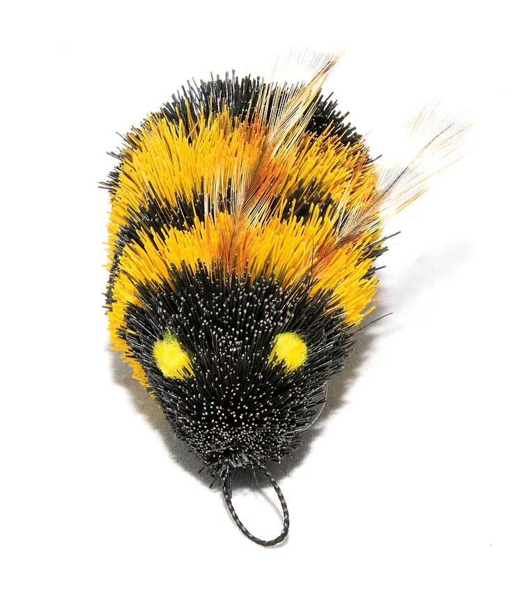 This is a Da Bee Teaser Wand Cat Toy Replacement Lure by Go Cat. The bee is a traditional black and yellow striped looking bumble bee. It has a cotter clip at its head so it can attach to teaser wands. There are also smaller tan-yellowish feathers protruding from the body. The bee is meant to engage a cat's hunting instincts. 