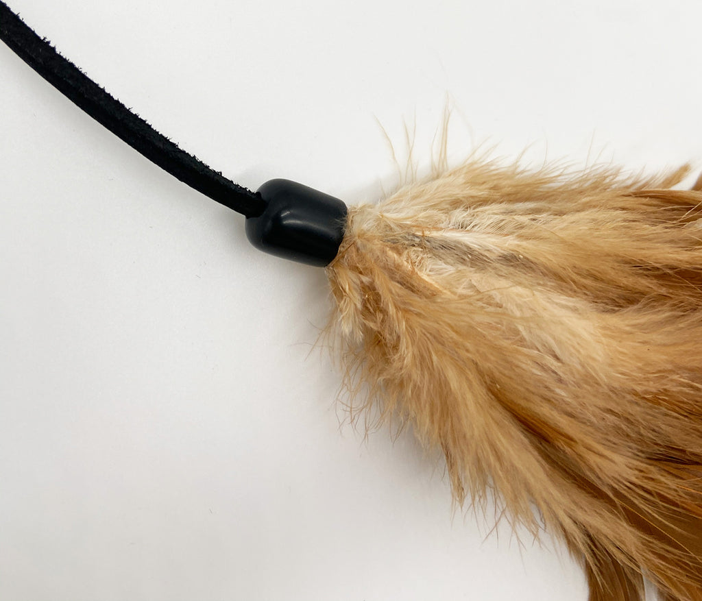 This is a close up of the PURRfect Pouncer Teaser Wand Cat Toy by Vee Enterprises. The photo is an actual close up of where the lure attaches to the leather lace, that is all natural leather. There are no metal pieces on the connection. It's a plastic connector. The toy engages the cat's hunting instincts. 